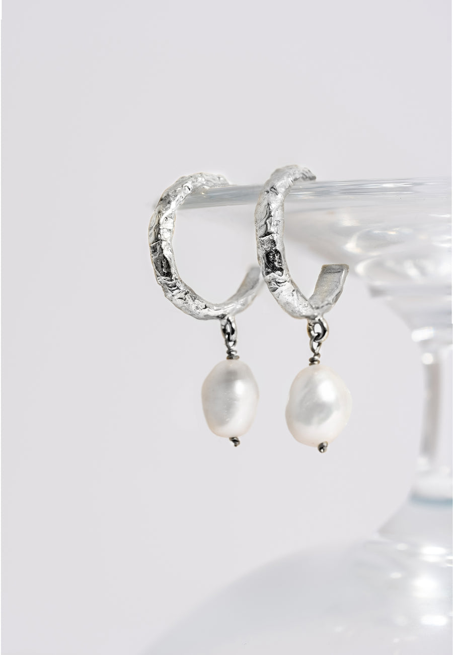 aros pequeños plateados con textura y perla pequeña colgante