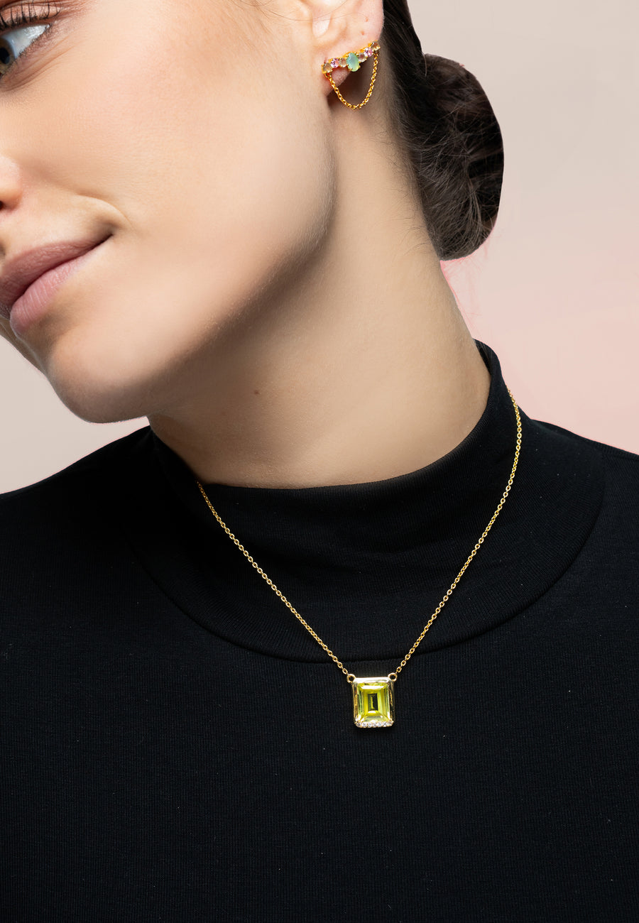 Modelo utilizando el colgante con piedra natural en verde con piedras en la parte inferior conbinado con pendientes trepadores.