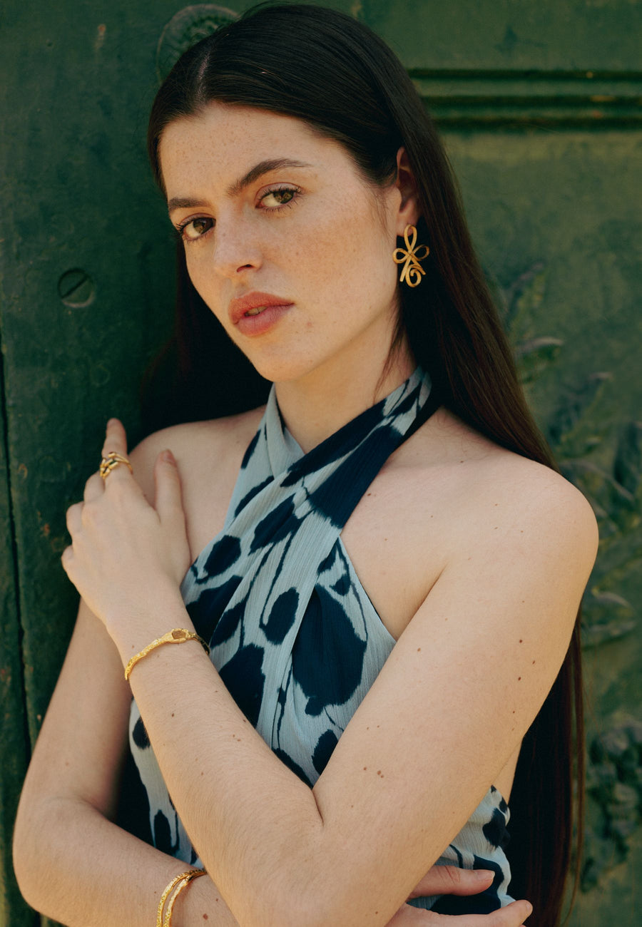 Modelo con brazalete de piedra citrino y pendientes unconditional love dorados
