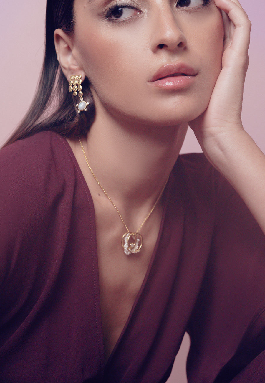 Collar con tres aros entrelazados: un aro dorado, un aro perlado y un aro con circonitas
