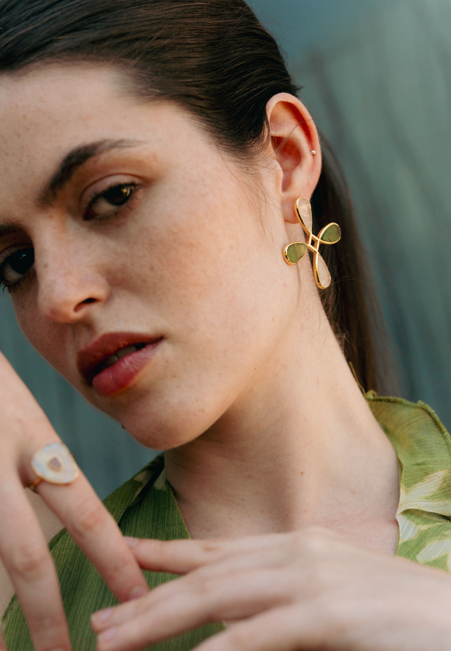 Foto de modelo con pendientes en forma de cruz verde y rosa