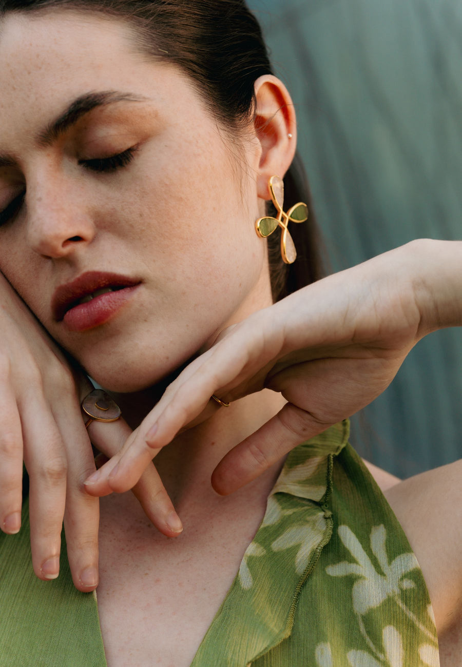 Foto de modelo con pendientes de cruz en rosa y verde