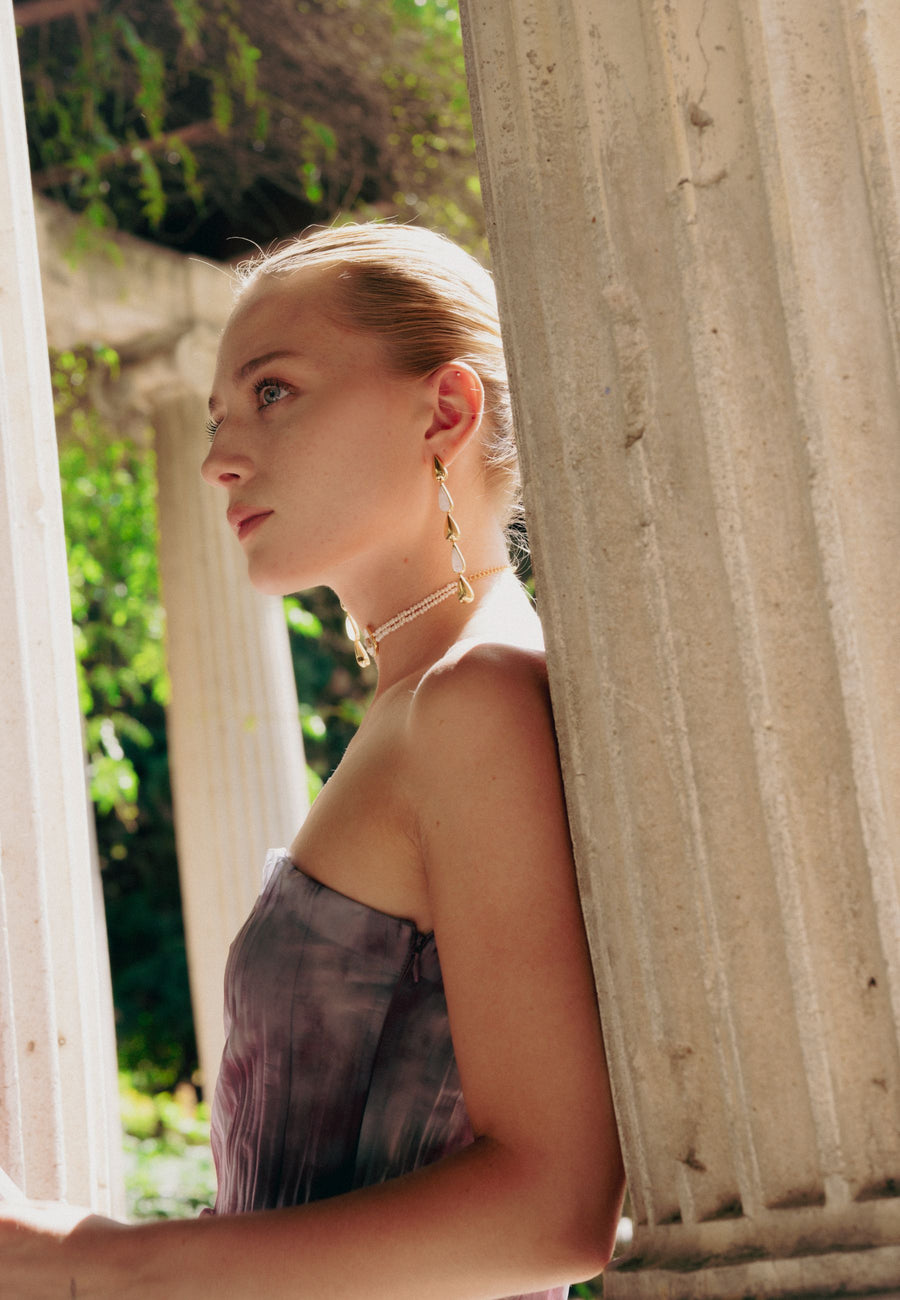pendientes de gota largos blancos combinados con look de invitada y choker de perlas