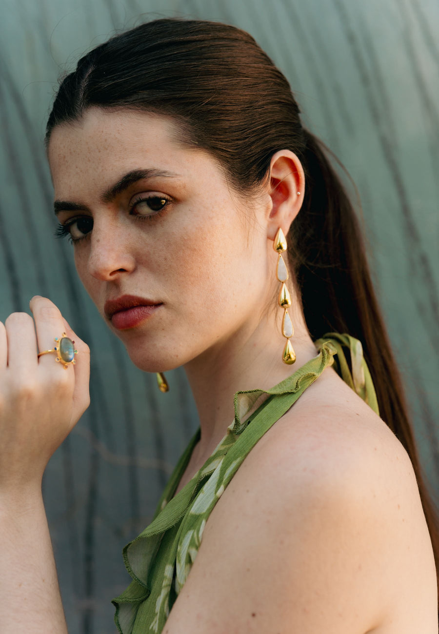 pendientes de gota largos con piedraluna combinados con anillo multicolor en look de invitada