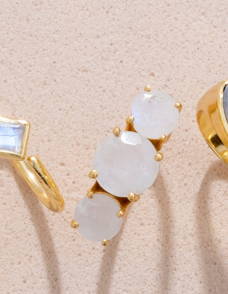 Detalle de anillo de piedra luna con piedras facetadas redondas.