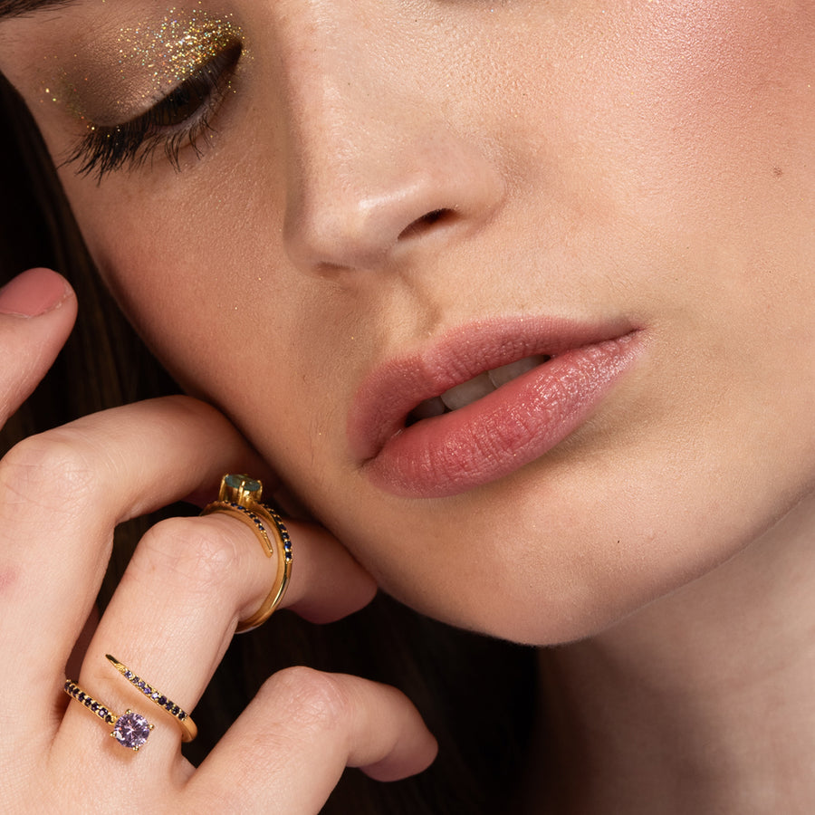 Mujer con anillo dorado regulable con circonitas rosas.