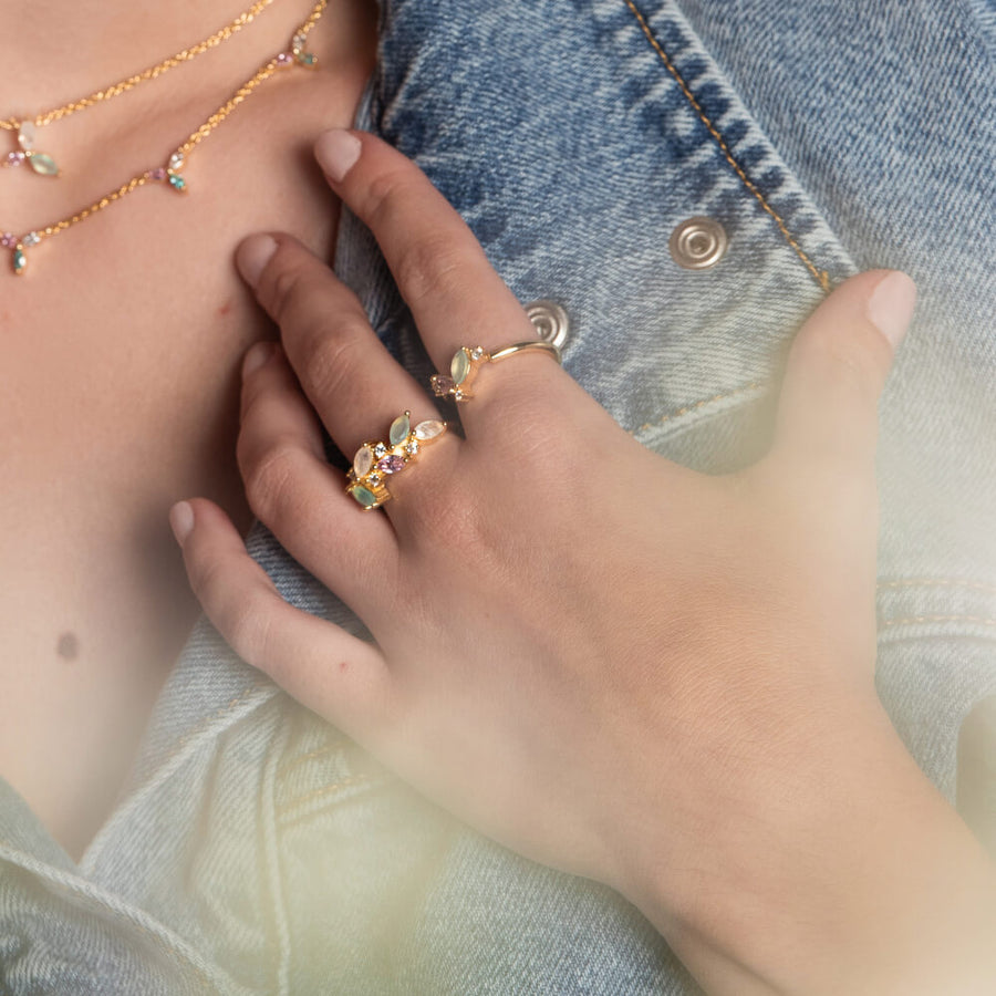 Modelo combinando joyas de la coleccion Nelumbo y anillos dorados ajustables