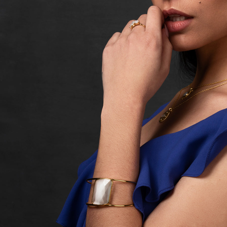 Modelo con Brazalete dorado y ancho con una piedra blanca en el centro