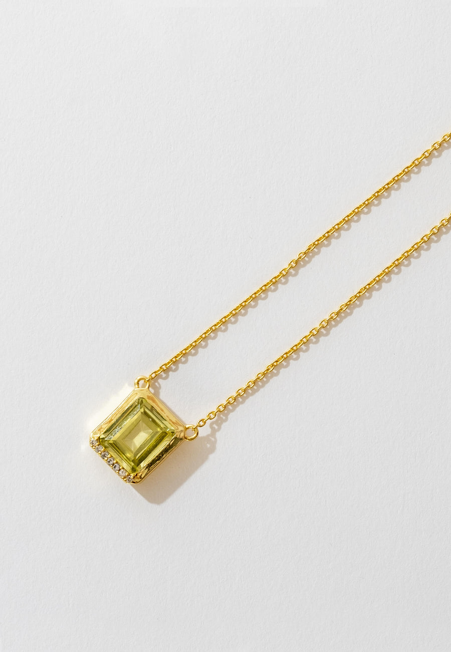 Colgante con piedra natural en verde con piedras en la parte inferior sobre fondo blanco.