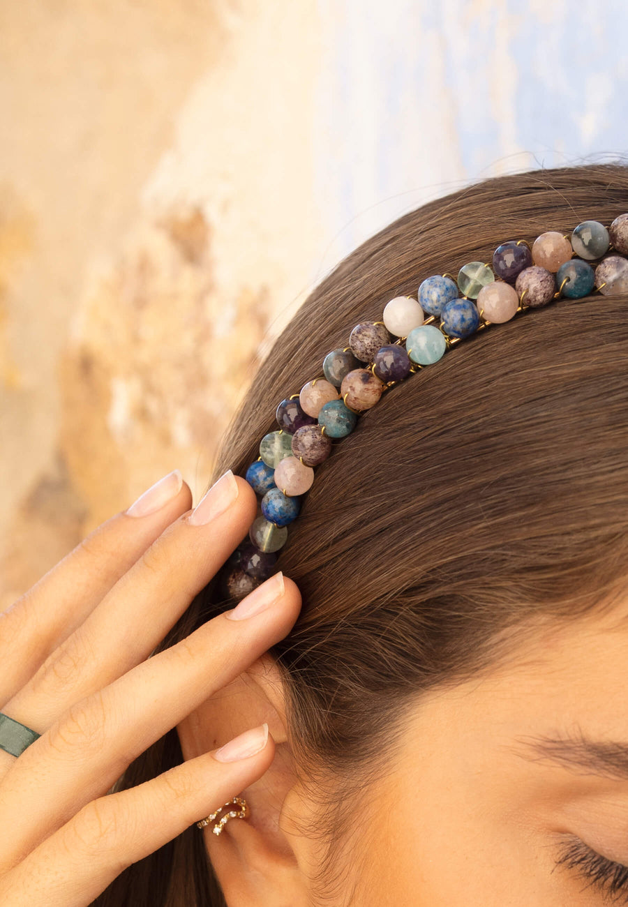 Detalle de la diadema de pedrería de colores en malvas, azules, verdes y blancos