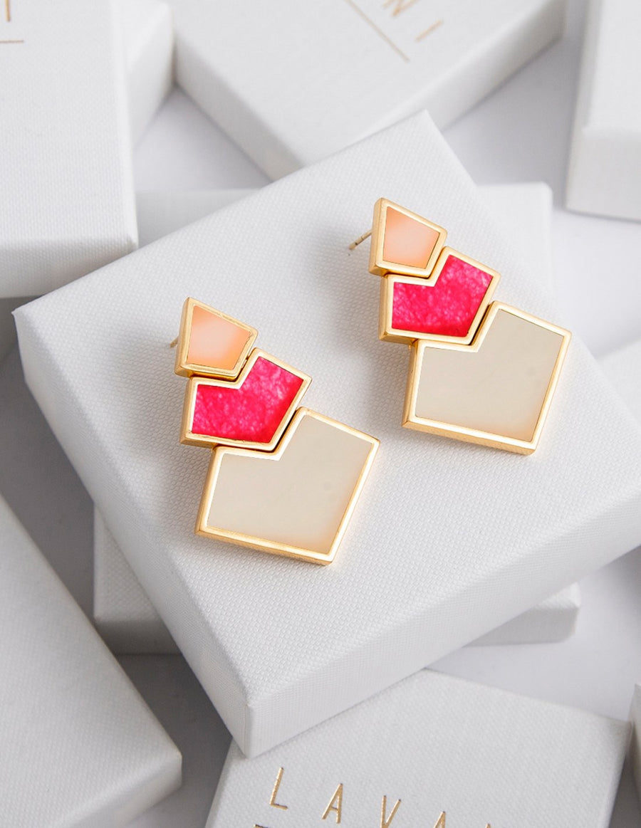 Pendientes rosas y fucsias sobre packaging de Lavani Jewels.