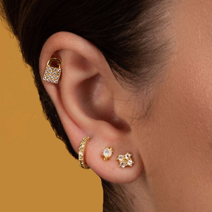 Mujer con varios piercing con piedras naturales de color blanco.