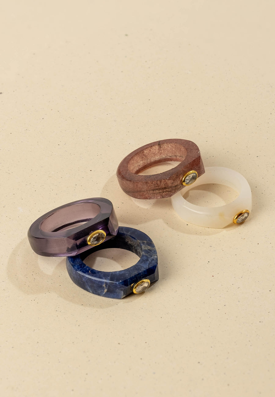 Anillo amatista morado junto a tres otros anillos de piedra natural