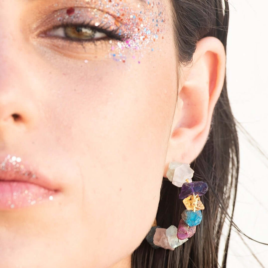 modelo con aros bañados en oro de piedras
