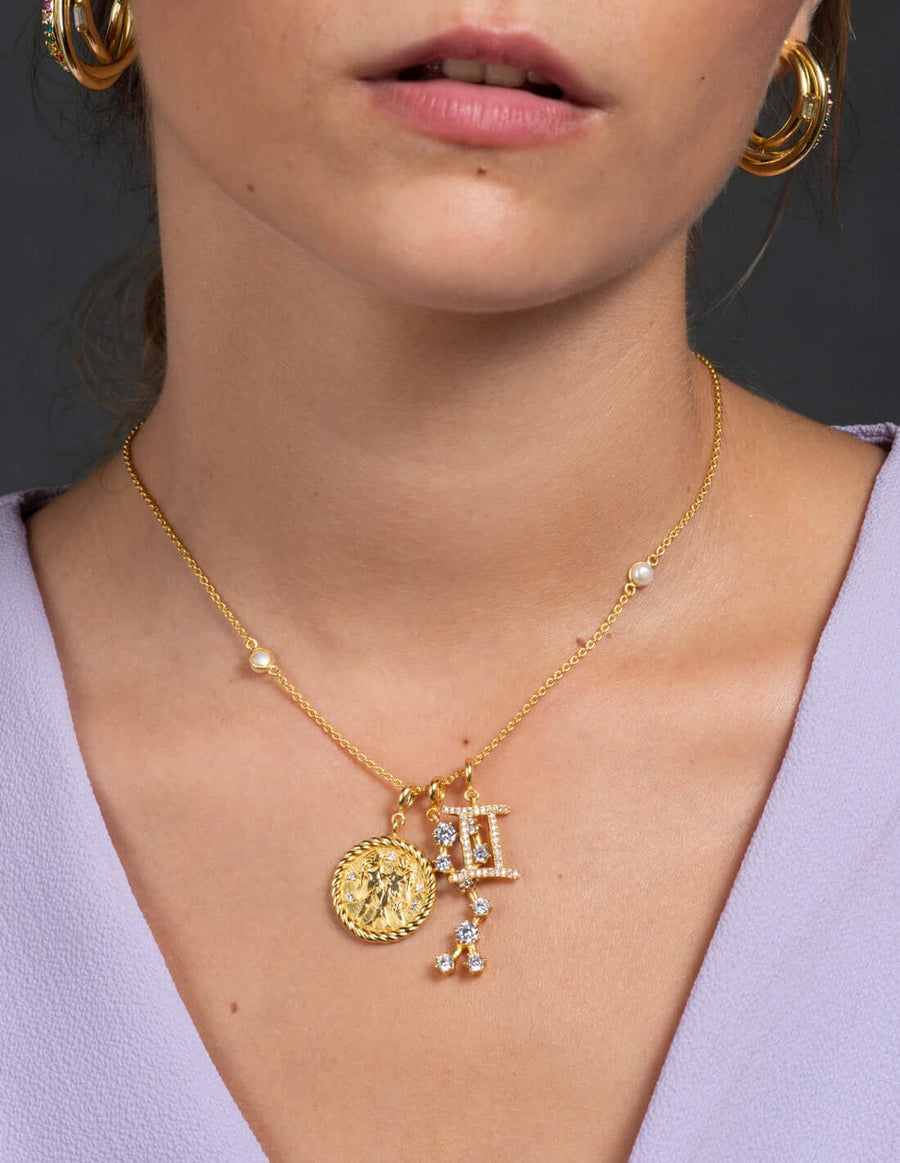 modelo luciendo cadenas doradas zodiaco