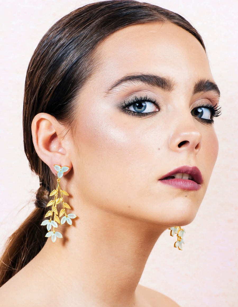 Modelo con pendientes largos detalles hoja con piedras naturales