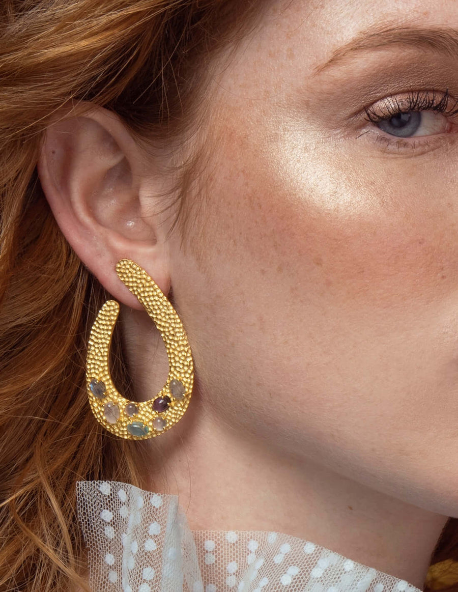 modelo con pendientes de invitada dorados