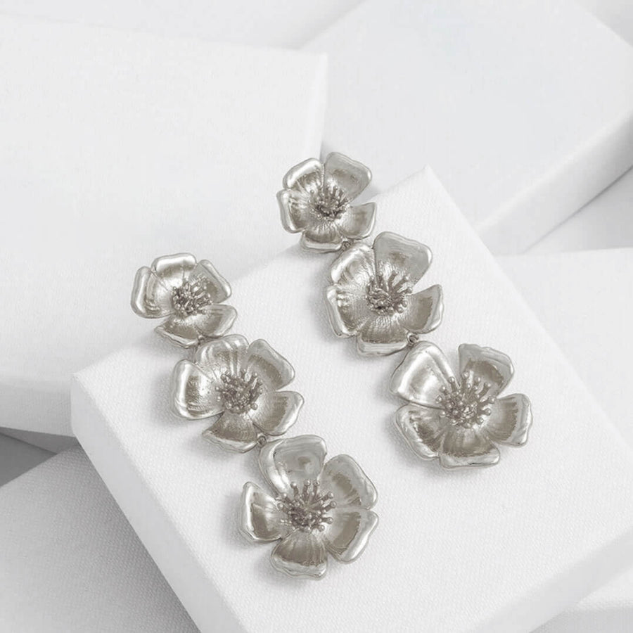 pendientes plateados con flores que cuelgan