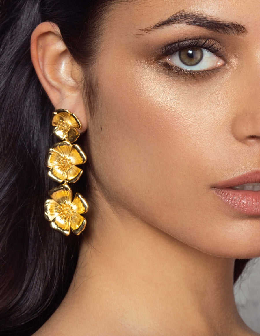 Modelo con pendientes largos flores dorados