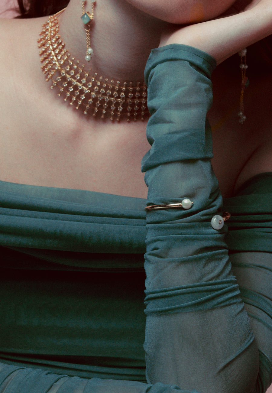 brazalete de perlas fino sobre brazo de modelo