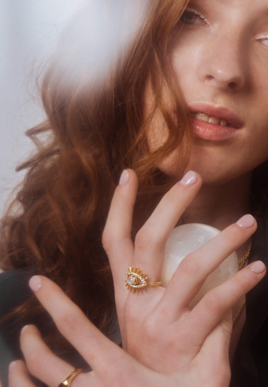 modelo con anillo de ojo turco con circonitas y piedraluna natural semipreciosa con bola mágica del tarot