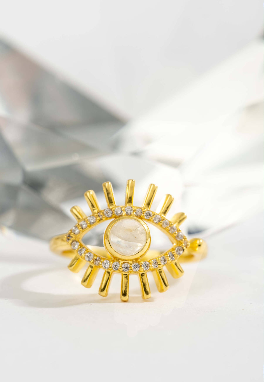 zoom de anillo de ojo turco con piedraluna central, circonitas como borde del ojo y salientes dorados que representan las pestañas