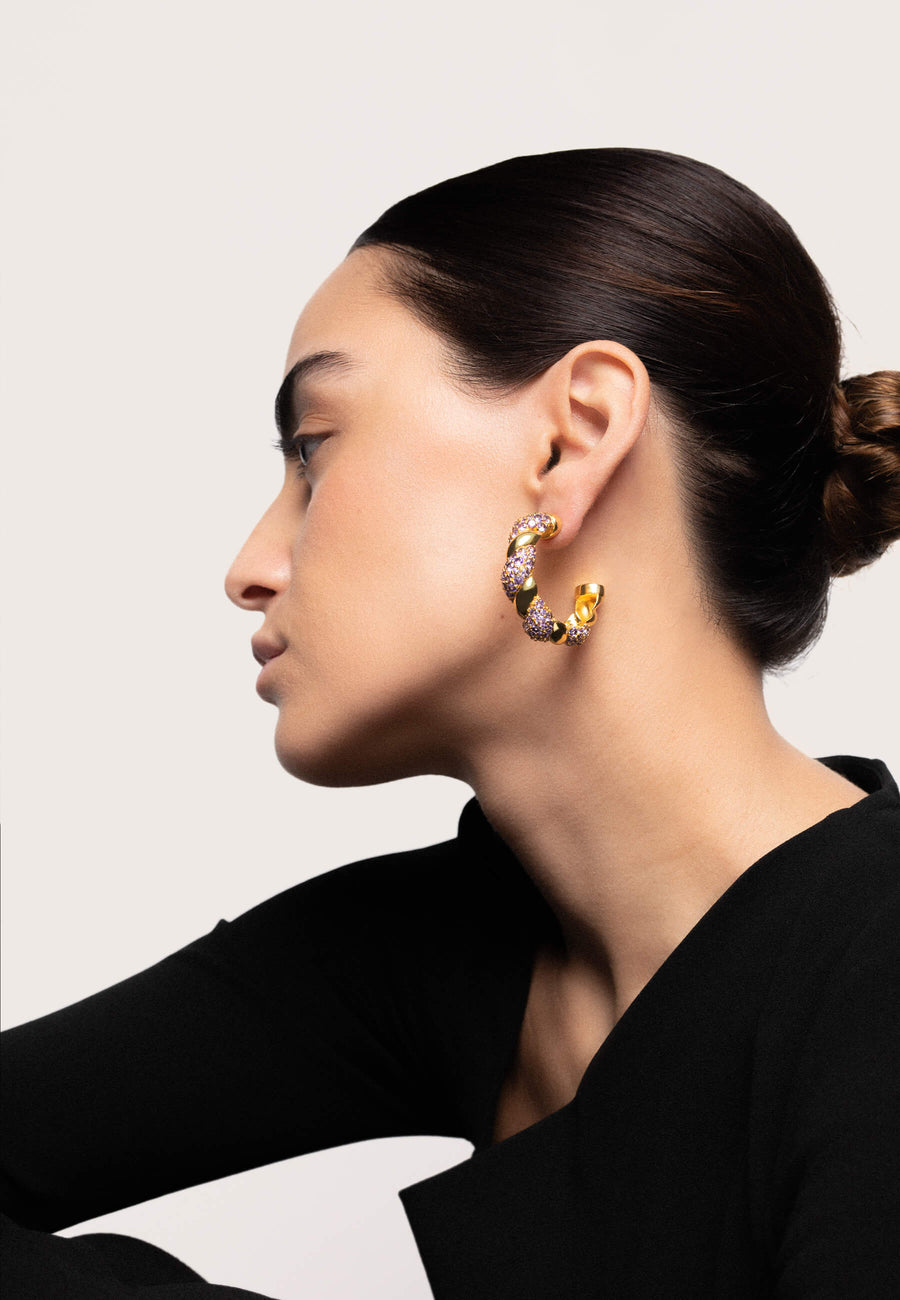 Pendientes tipo aros entrelazados morados con piedras circonitas y baño de oro