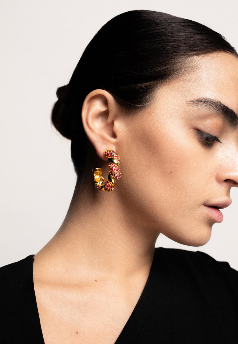 Aros entrelazados fucsias con circonitas rosas y baño de oro de 18 quilates