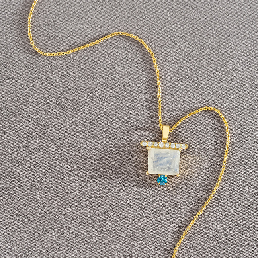 Detalle del colgante dorado con piedras naturales de diseño rectangular com baño de oro de 22 quilates 