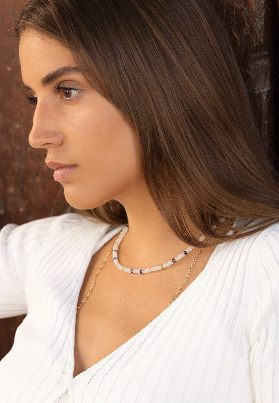 Modelo de lado utilizando el collar de Piedra Luna de colores hecho con cuentas de la piedra Luna blanca