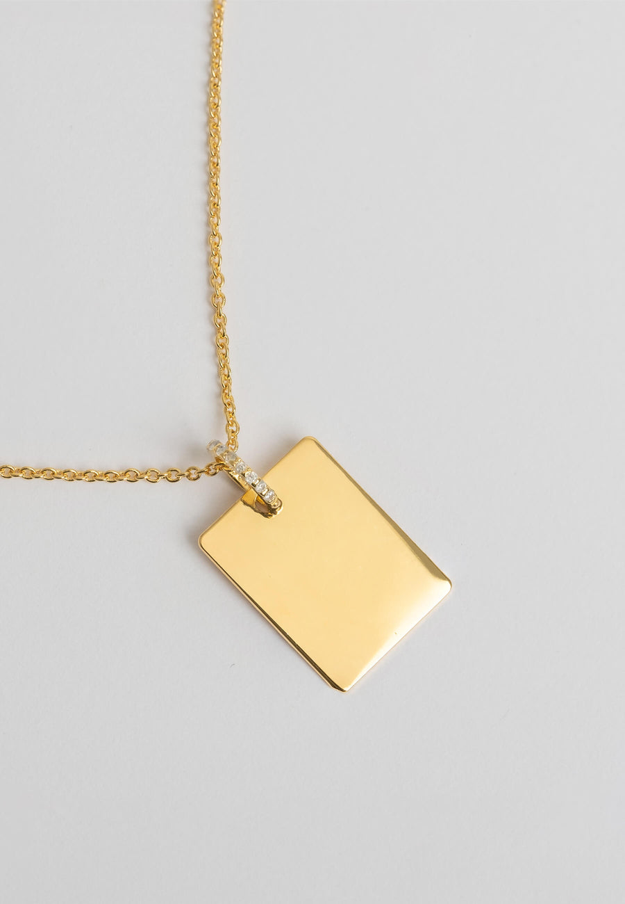 Colgante rectangular dorado grabado de Lavani Jewels de cerca